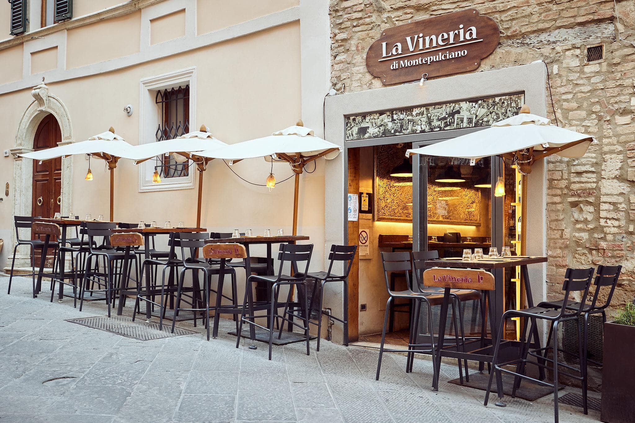 La facciata del numero 101, con i tavoli e gli sgabelli allineati lungo la via